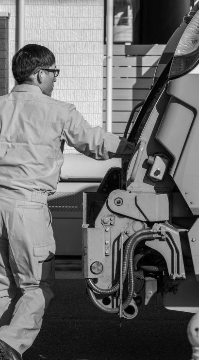 ごみ収集車にゴミを積む人の写真